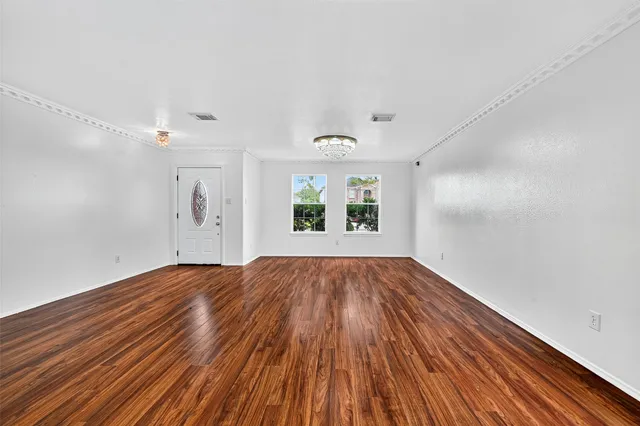 wooden floor in an empty room with a window