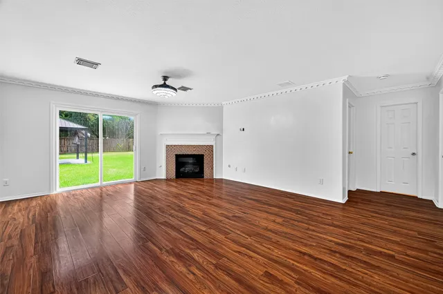 a view of an empty room with a fireplace and a window
