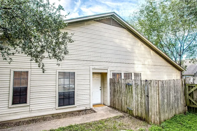 a view of a house with a yard and wooden fence