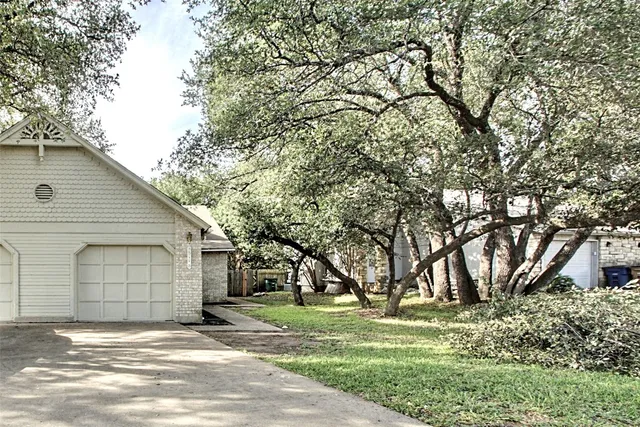 a view of a house with a yard and tree