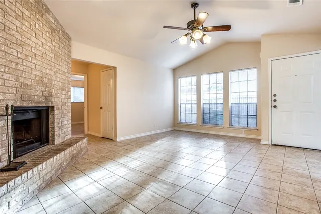 a view of an empty room with window and chandelier fan