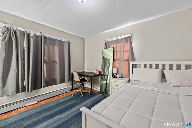 a living room with furniture a flat screen tv and a table