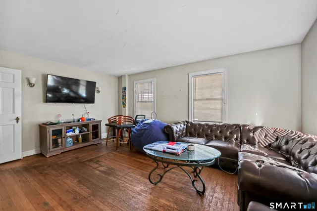 a living room with furniture and wooden floor