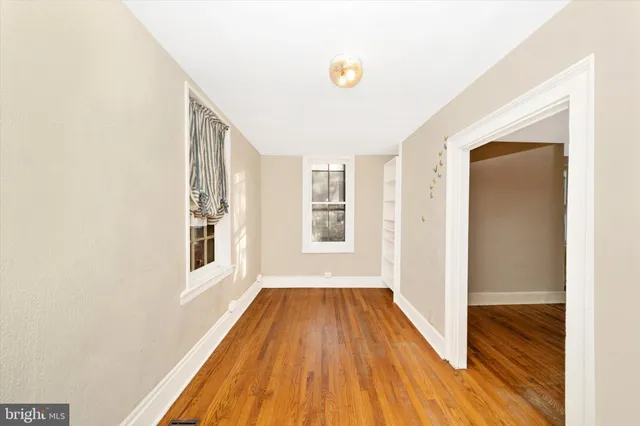 a view of a room with wooden floor and a ceiling fan