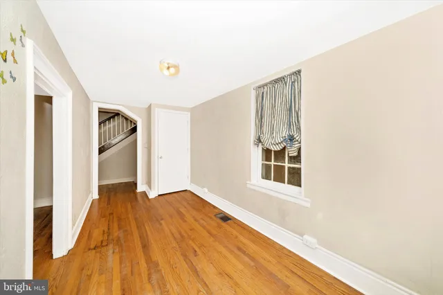 a view of empty room with wooden floor