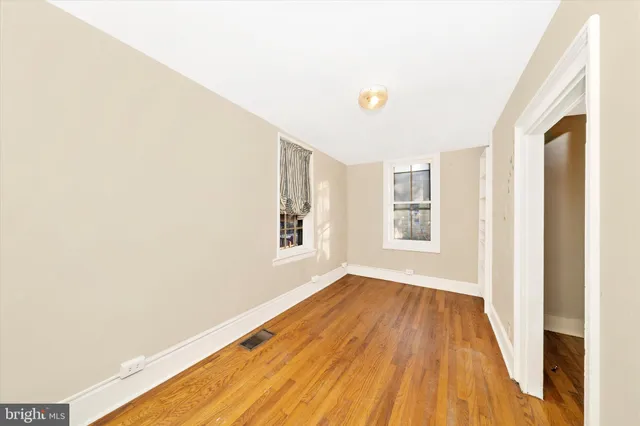a view of an empty room with wooden floor