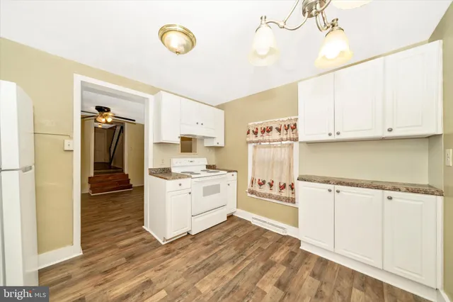 a kitchen with granite countertop a stove a sink and a refrigerator