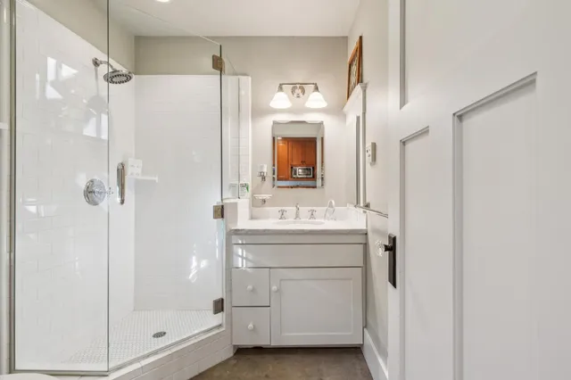 a bathroom with a shower sink and mirror