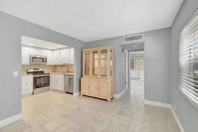 a kitchen with granite countertop white cabinets and stainless steel appliances