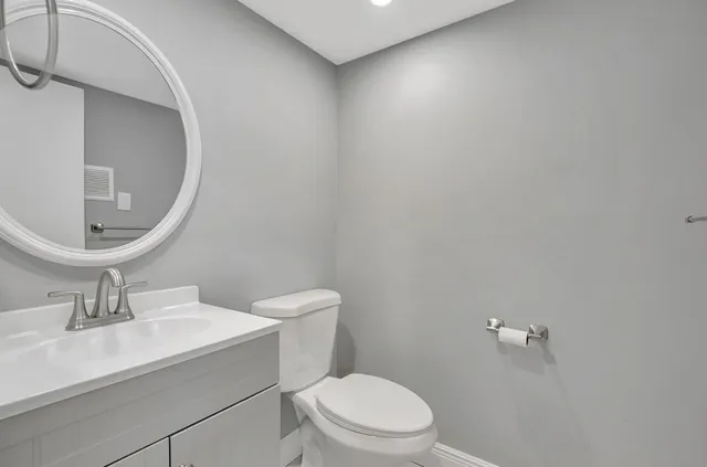 a bathroom with a sink a toilet and a mirror