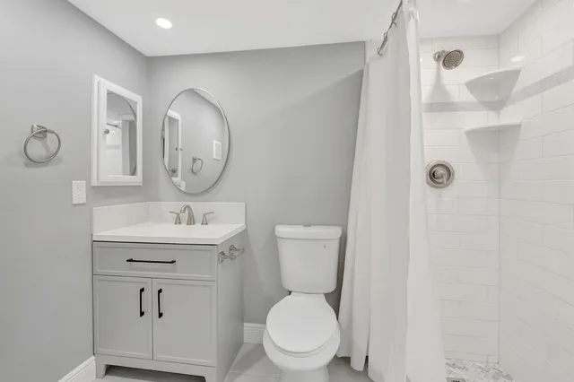 a bathroom with a toilet a sink and mirror