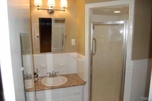 3213 Oak Grove Circle Raleigh, NC 27607 - Photo 7 of 10 a bathroom with a granite countertop shower sink and mirror