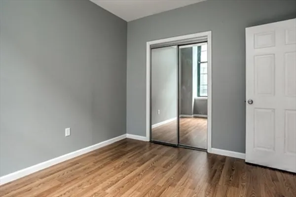 an empty room with wooden floor and closet
