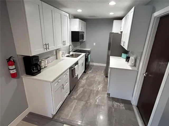 a kitchen with a sink a stove a refrigerator and a microwave