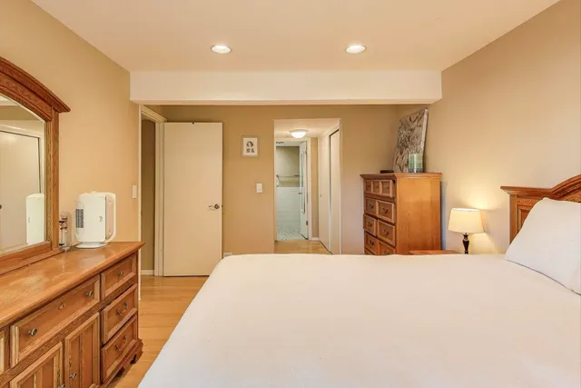 a bedroom with a bed and a dresser with mirror