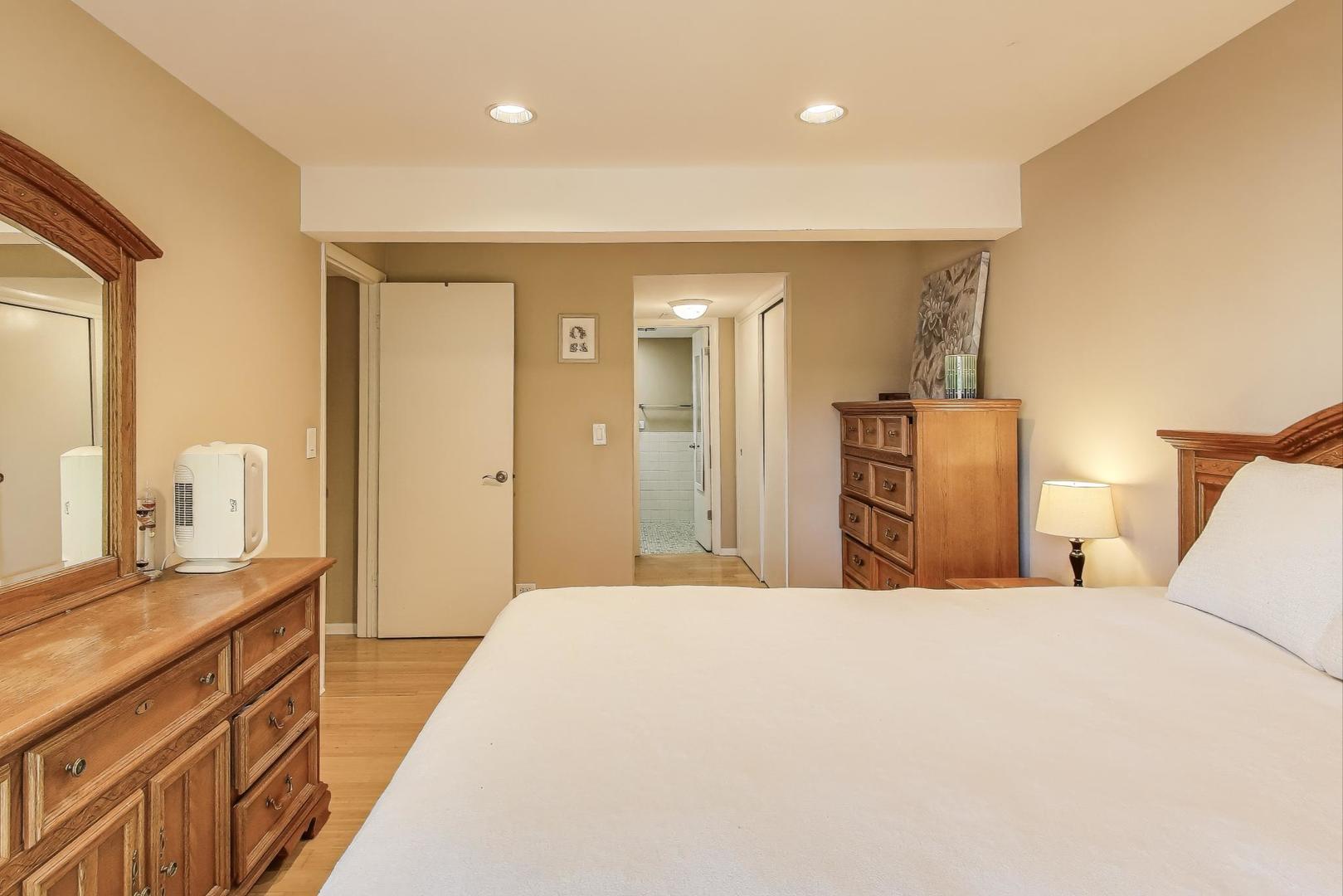 1847 Tanglewood Drive, Unit 2B Glenview, IL 60025 - Photo 11 of 26 a bedroom with a bed and a dresser with mirror