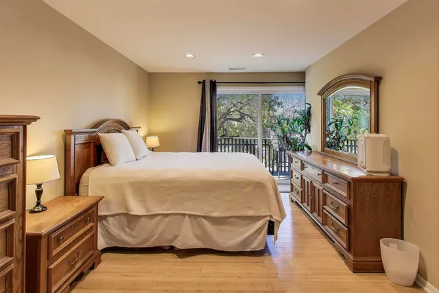 a bedroom with a large bed and a flat tv screen on dresser