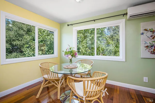 a dining room with furniture window and wooden floor