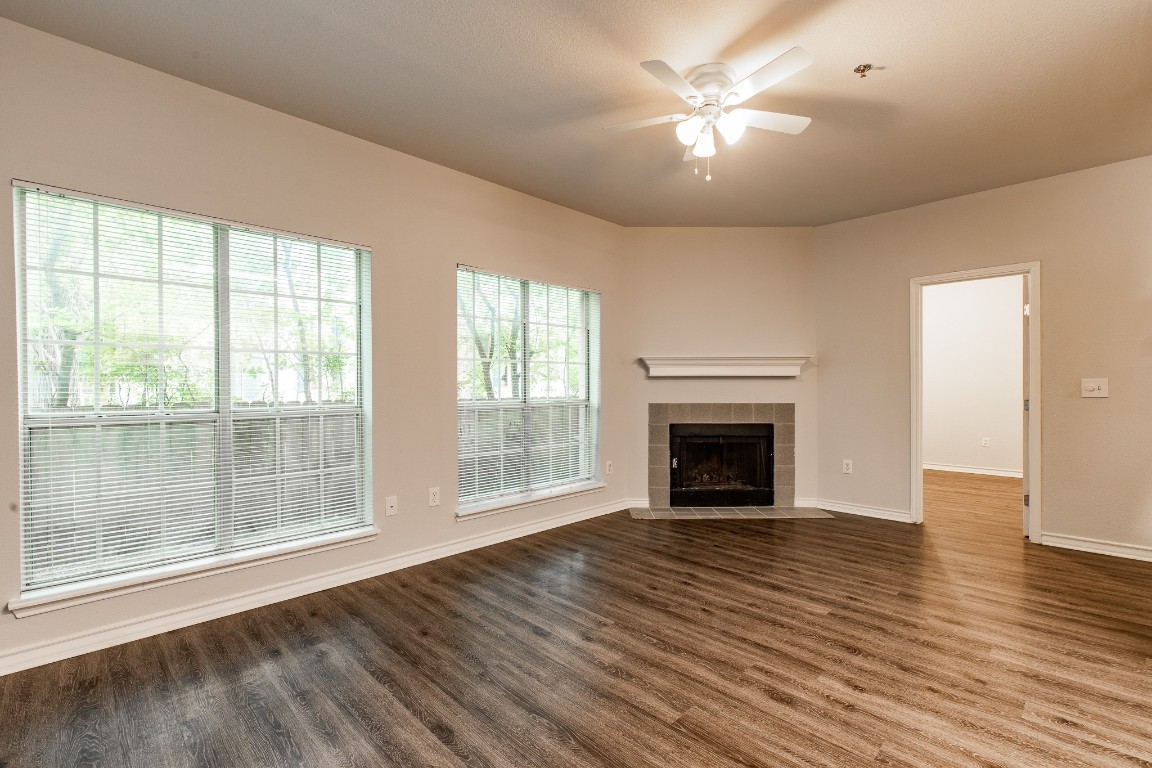 2204 San Gabriel Street, Unit 104 Austin, TX 78705 - Photo 4 of 18 Unfurnished living room with ceiling fan, dark wood-style floors, and a fireplace