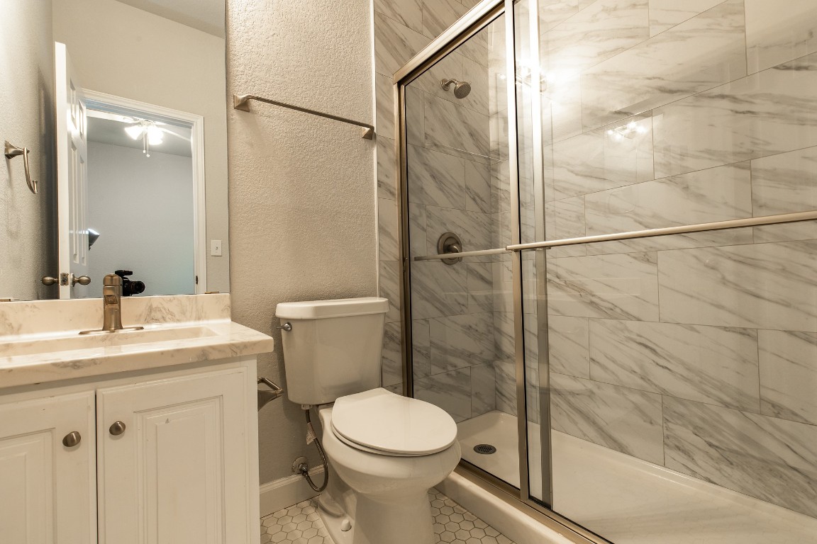 2204 San Gabriel Street, Unit 104 Austin, TX 78705 - Photo 5 of 18 Full bath with a shower stall, vanity, and tile patterned floors