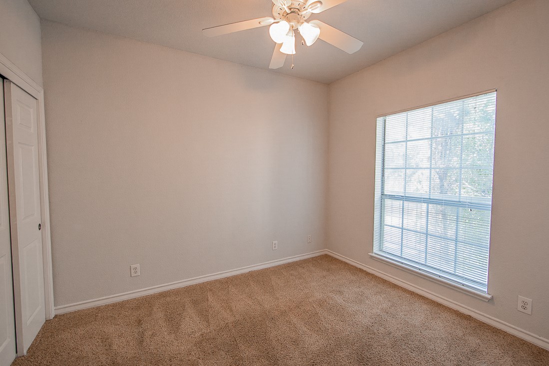 2204 San Gabriel Street, Unit 104 Austin, TX 78705 - Photo 9 of 18 Unfurnished bedroom with carpet flooring, a closet, and ceiling fan