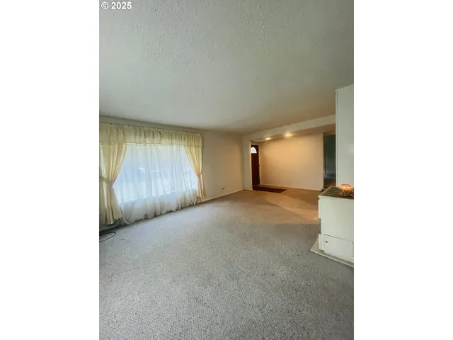 a view of a room with wooden floor and window