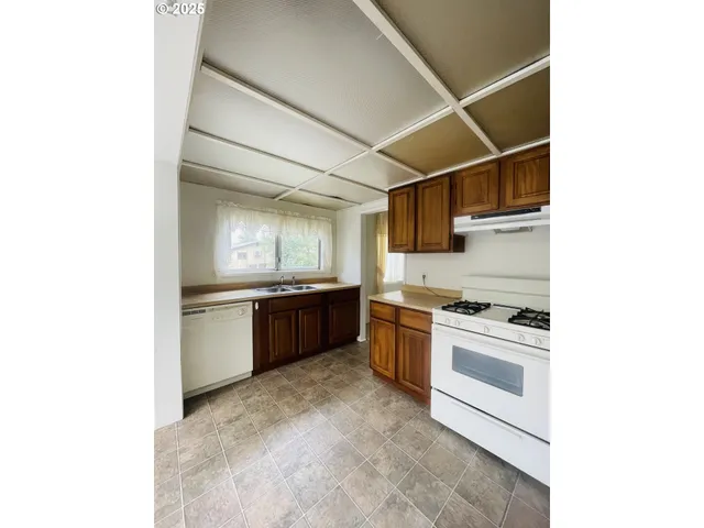 a kitchen with stainless steel appliances kitchen island granite countertop a sink and cabinets