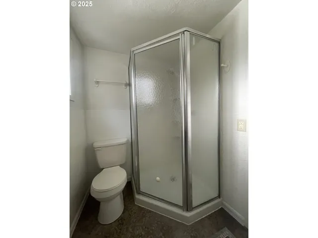 a bathroom with a toilet and a shower