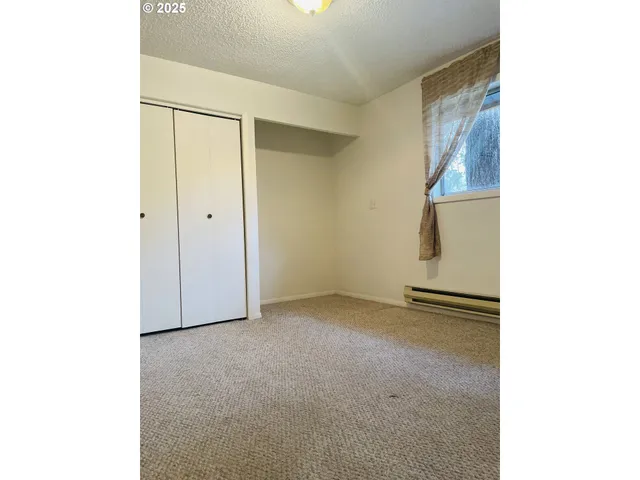 a bathroom with a granite countertop toilet a sink a mirror and a shower