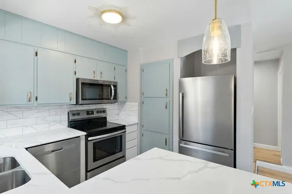 a kitchen with stainless steel appliances a refrigerator stove and microwave