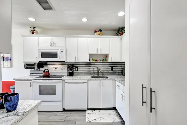 a kitchen with stainless steel appliances granite countertop a sink and a stove
