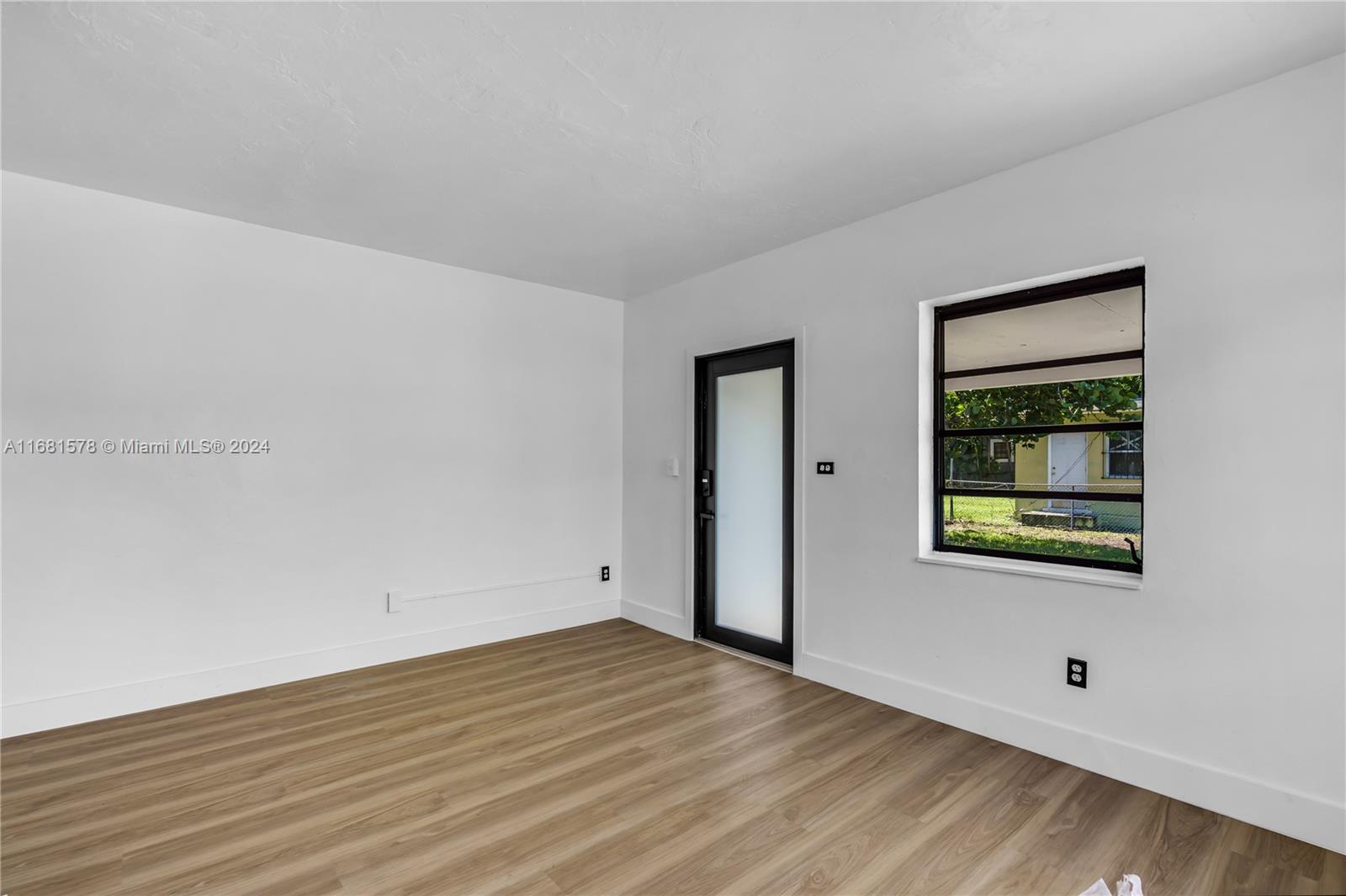 1400 Northwest 55th Street Miami, FL 33142 - Photo 19 of 33 an empty room with wooden floor and windows