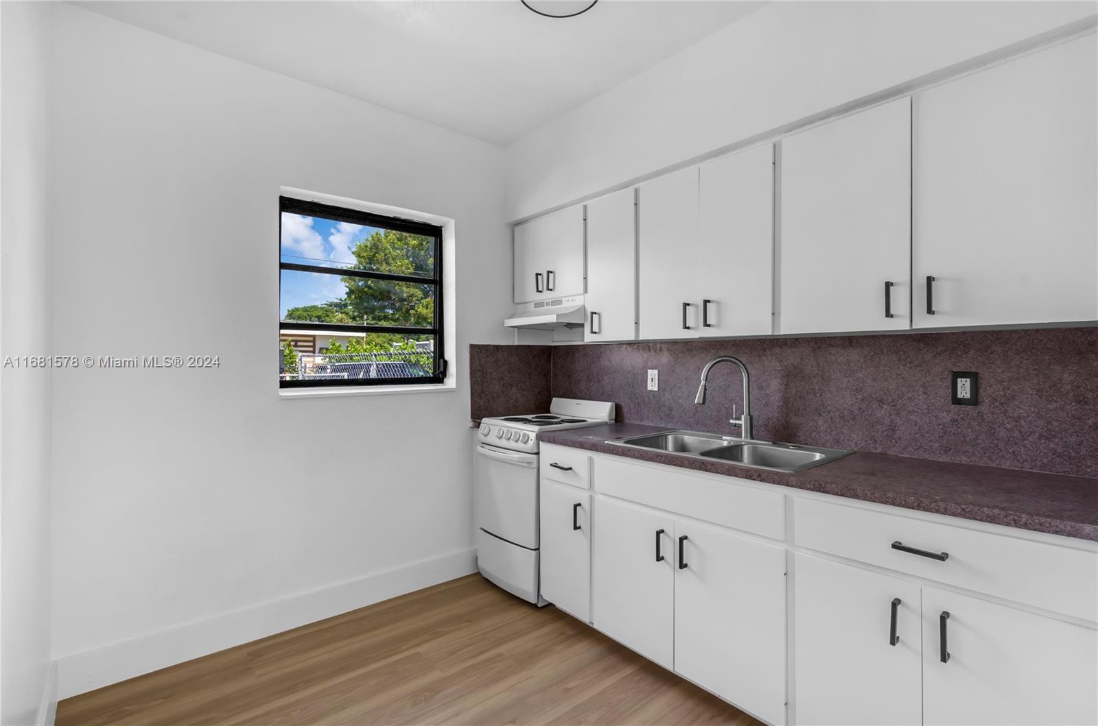 1400 Northwest 55th Street Miami, FL 33142 - Photo 21 of 33 a kitchen with stainless steel appliances granite countertop a sink stove and cabinets