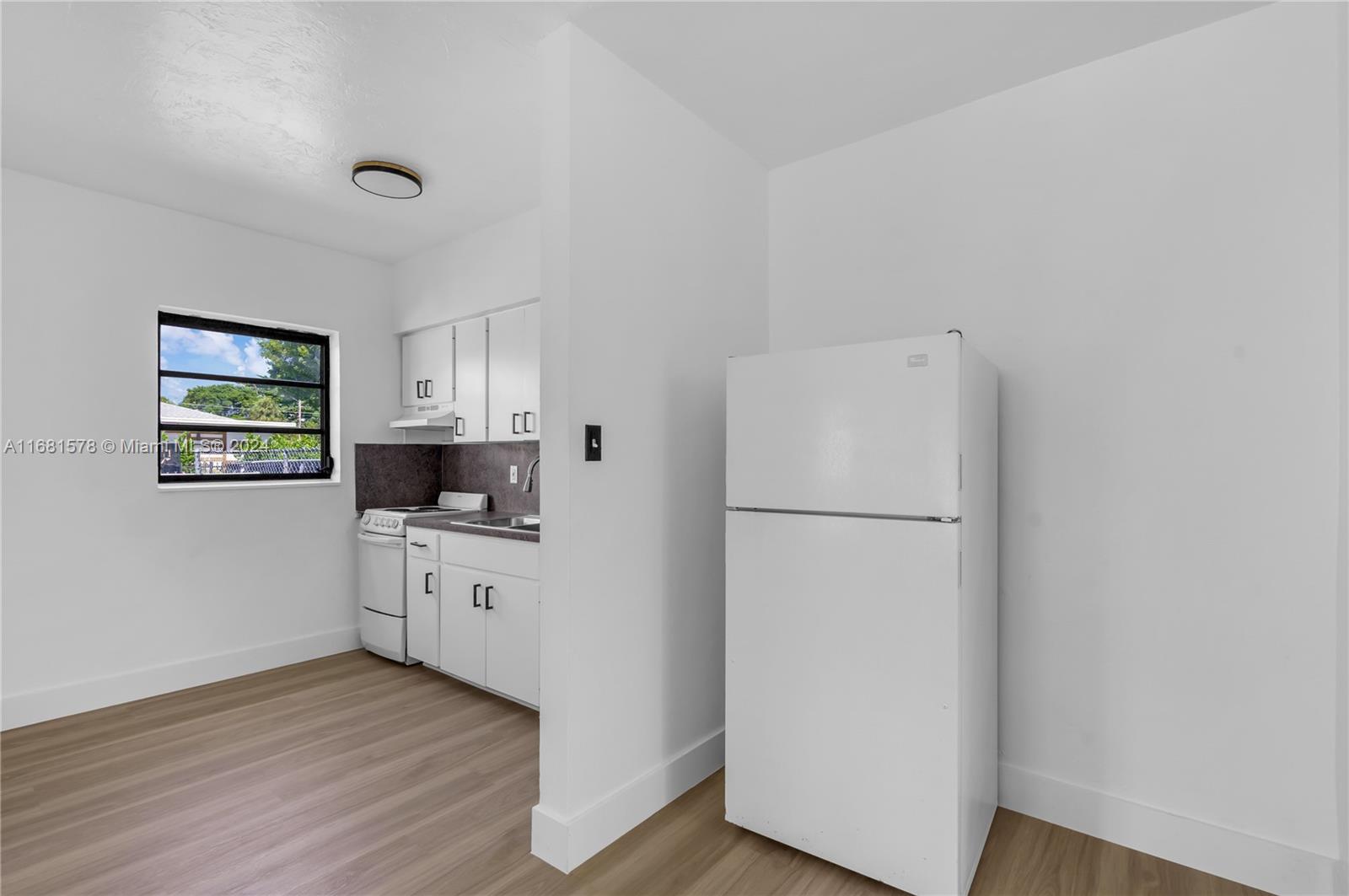 1400 Northwest 55th Street Miami, FL 33142 - Photo 26 of 33 a kitchen with white cabinets and white appliances