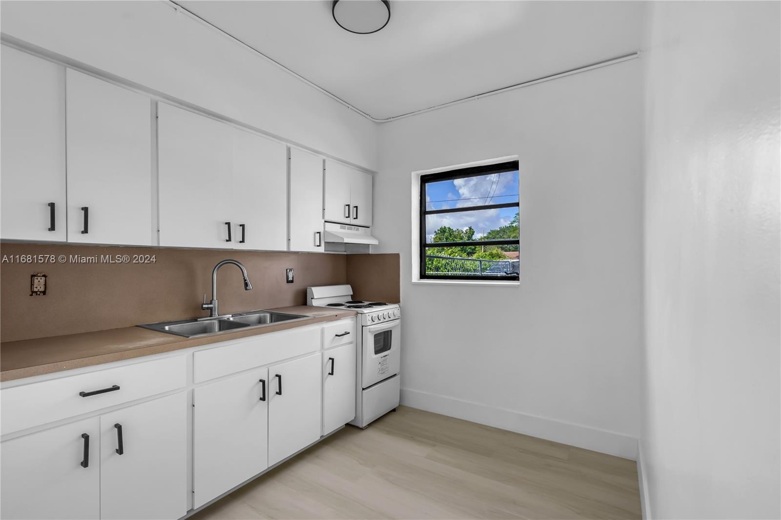 1400 Northwest 55th Street Miami, FL 33142 - Photo 7 of 33 a kitchen with a sink cabinets and window