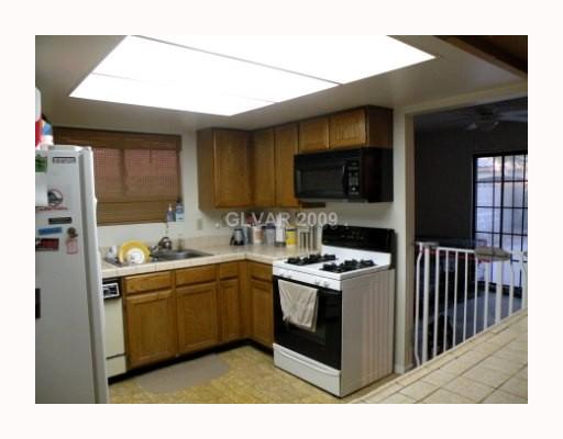 5518 West Viking Road Las Vegas, NV 89103 - Photo 6 of 12 Kitchen. Formal dining room through door with slider to pool area and back yard. Breakfast bar opens to family room.