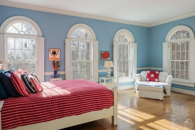 a bedroom with a bed and windows