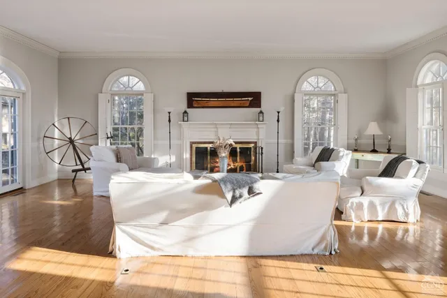 a living room with fireplace furniture and a large window