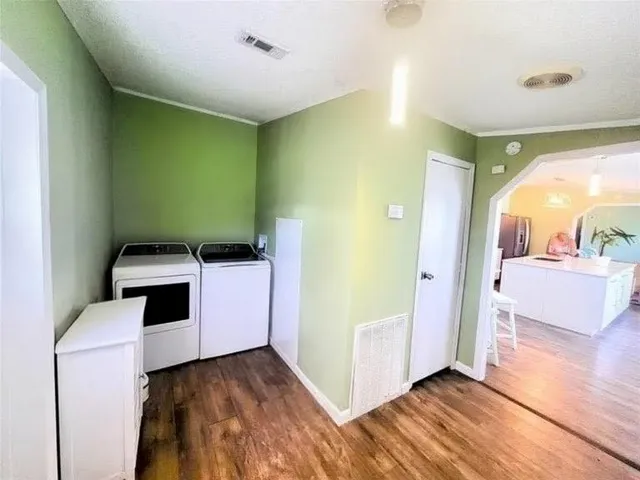 a view of a livingroom with wooden floor and furniture
