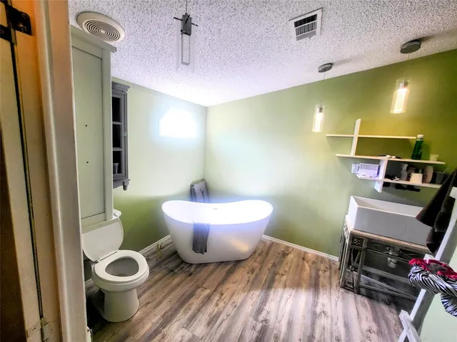 a spacious bathroom with a toilet sink and mirror