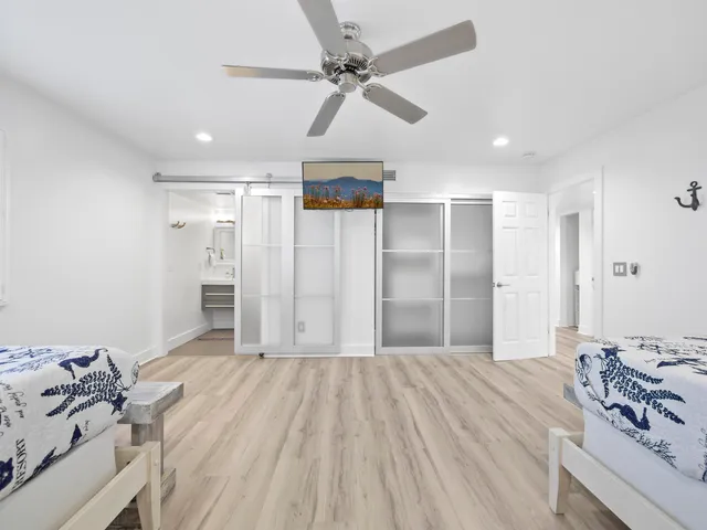 a bedroom with a large bed and a ceiling fan