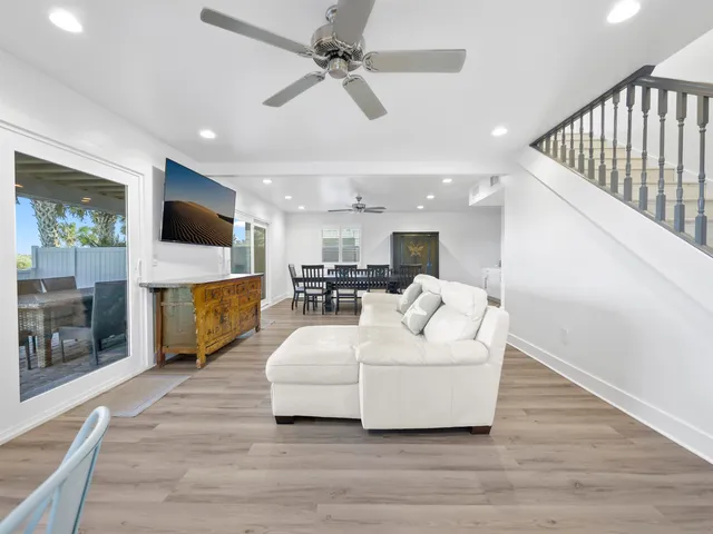 a living room with furniture a flat screen tv and a floor to ceiling window