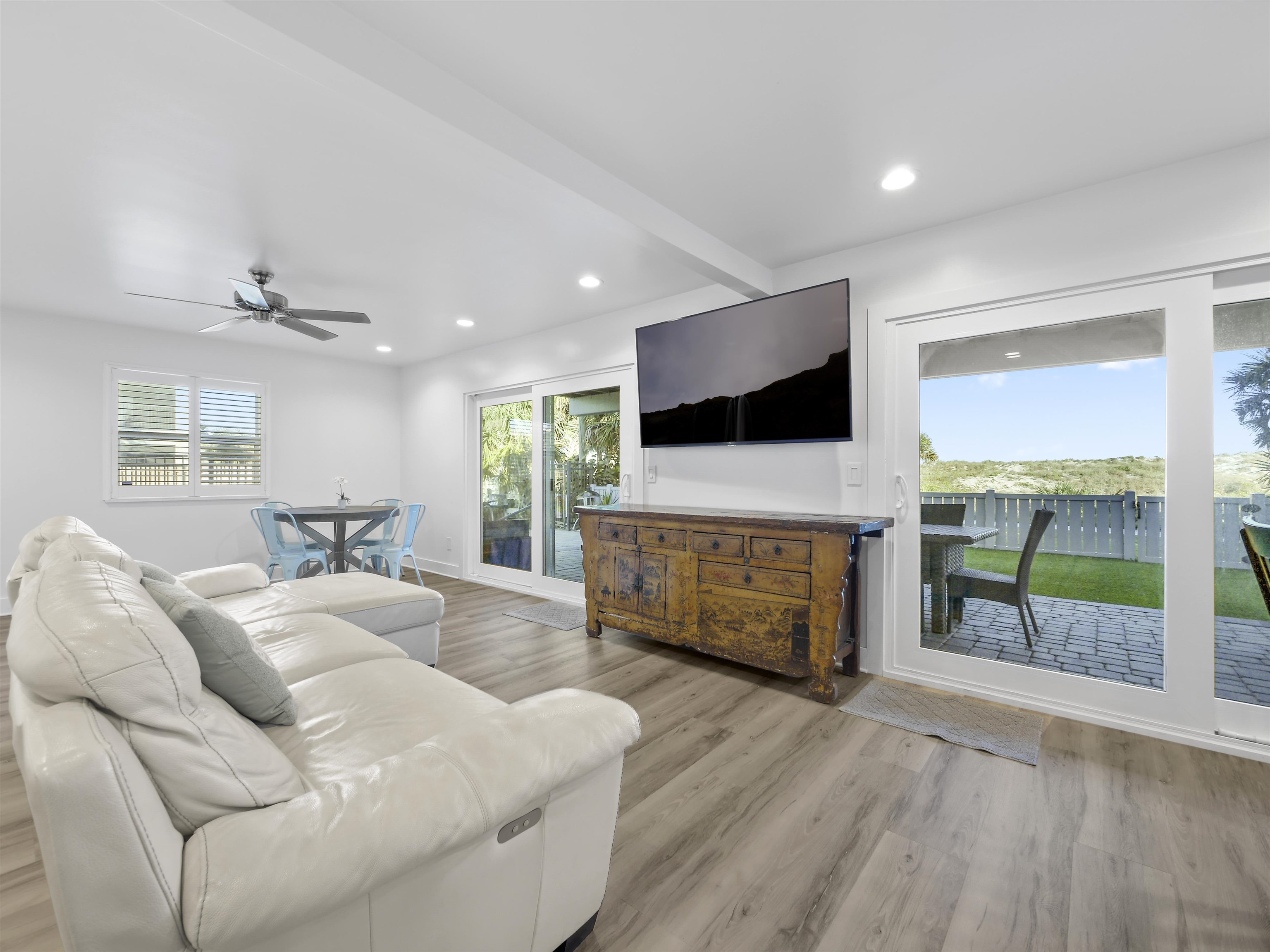 1 E Street St. Augustine, FL 32080 - Photo 9 of 54 a living room with furniture a flat screen tv and a floor to ceiling window
