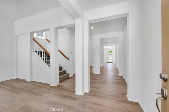 a view of a hallway with wooden floor and entryway