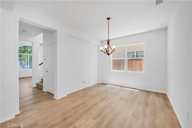 a view of empty room with wooden floor and ceiling fan