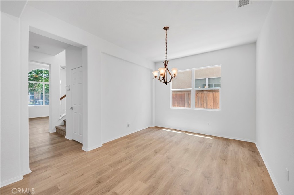 1984 Bronte Road San Jacinto, CA 92583 - Photo 6 of 30 a view of empty room with wooden floor and ceiling fan