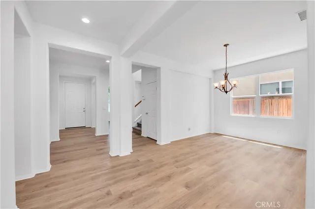 a view of empty room with wooden floor and ceiling fan