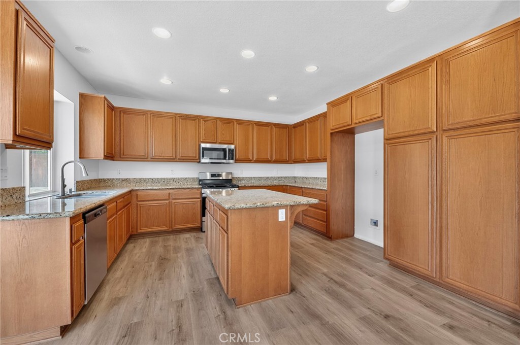 1984 Bronte Road San Jacinto, CA 92583 - Photo 9 of 30 a kitchen with stainless steel appliances granite countertop a stove a sink dishwasher a refrigerator and a microwave oven with wooden floor