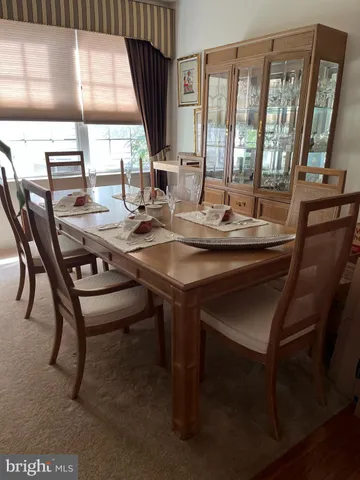 a kitchen with granite countertop wooden cabinets dining table and chairs
