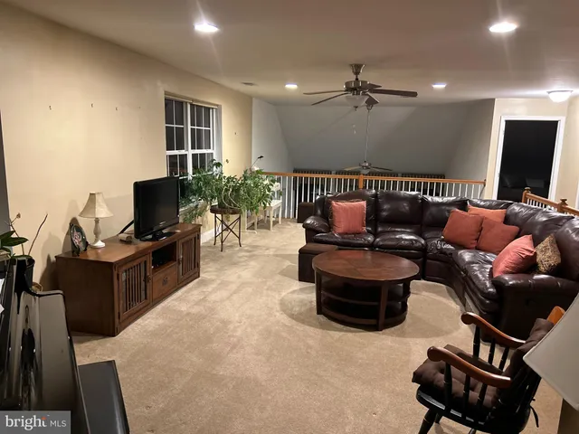 a living room with furniture a lamp and a flat screen tv
